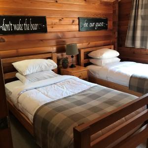 Oxtongue Lake三叶草别墅酒店的木墙客房 - 带两张单人床