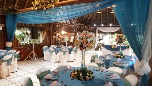 普约Hosteria Flor de Canela的宴会厅配有蓝色的桌子和白色的椅子