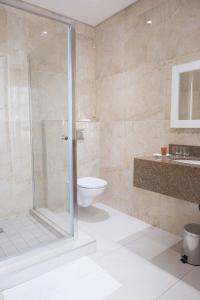 德班Britannia Hotel的带淋浴、卫生间和盥洗盆的浴室