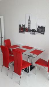 敖德萨Apartments Lutsdorf的一间用餐室,配有红色的椅子和桌子