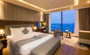 芽庄DTX Hotel Nha Trang的一间卧室配有一张床、一张书桌和一个大窗户