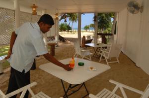 尼拉瓦利鸽子岛海滩度假村的站在桌子旁喝着饮料的人