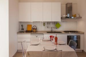 圣维托诺曼Piccinnu - apartment and spacious grounds的厨房配有桌椅和白色橱柜。