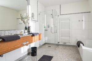 Lellichow勒里考沃兰德酒店的带淋浴和盥洗盆的白色浴室