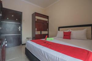 巴厘巴板RedDoorz near E Walk Mall Balikpapan的卧室配有带红色枕头的大型白色床
