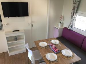 波雷奇CHERRY Premium ADRIA Mobile homes Zelena Laguna的一间带桌子和紫色沙发的用餐室
