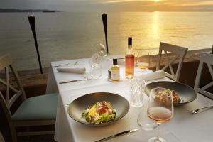 安卡兰赛德拉别墅 - 亚德里亚安卡拉酒店加度假胜地的一张桌子,上面放着两盘食物和酒杯