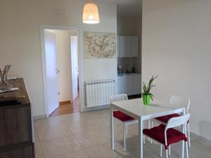 菲乌米奇诺Bed&Breakfast Riccio&Lella的厨房以及带白色桌椅的用餐室。