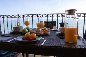 珀特萨普拉亚Sea You Apartamentos Valencia Port Saplaya的餐桌,带食物盘和橙汁杯