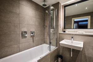 翰索Llanerch Vineyard Hotel的带浴缸、水槽和镜子的浴室