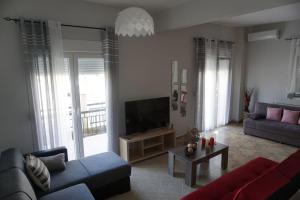 帕拉利亚狄奥尼索Seaside family Apartment in Paralia Dionisiou的带沙发和电视的客厅