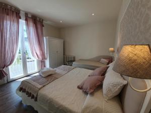 西尔米奥奈Romantic Home的一间卧室配有一张带灯和窗户的床