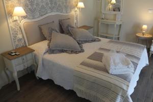西尔米奥奈Romantic Home的卧室配有带枕头和镜子的白色床