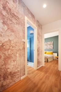 特雷维索Suite Manin的一间设有石墙和滑动玻璃门的房间
