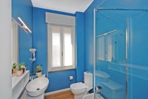 特雷维索Suite Manin的蓝色的浴室设有卫生间和淋浴。