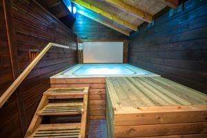 科尼尔-德拉弗龙特拉El Caseron de Conil & Spa的木制桑拿浴室内的热水浴池,设有楼梯