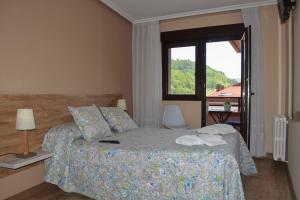 坎加斯-德奥尼斯Pension Reconquista的一间卧室设有一张床和一个美景窗户。