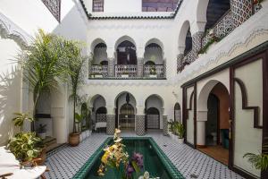 马拉喀什Riad Maison Belbaraka的一座带游泳池的室内庭院,位于一座建筑中