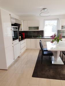 BlankenhagenFewo II Familie Sobierajczyk的厨房配有白色橱柜和白色桌椅