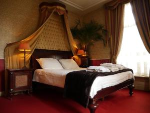 阿珀尔多伦天马大酒店的一间卧室配有一张带天蓬的大床