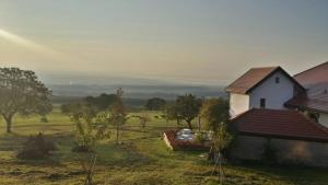 La Praz普拉兹农场住宿加早餐旅馆的坐在房子旁边的田野上的白色房子