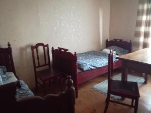 RucavaLauku viesu māja Bajāri的一间设有两张床和一张桌子及椅子的房间