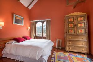 奥兰太坦波SAUCE Hotel Boutique的一间卧室拥有橙色的墙壁,配有一张床和一个梳妆台