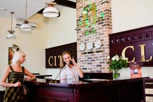 哈尔科夫城市俱乐部酒店的两个站在一个柜台上,在手机上说着话的女人