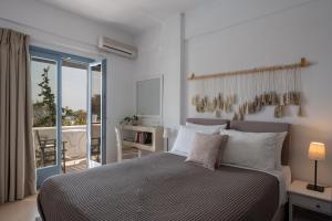 阿克罗蒂里Caldera Romantica Hotel的一间带大床的卧室和一个阳台