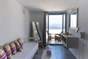 阿克罗蒂里Caldera Romantica Hotel的带沙发的客厅,享有海景
