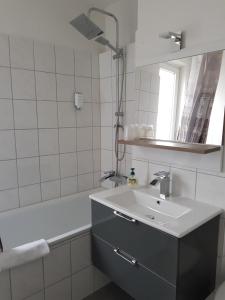 汉诺威LANE City Laatzen的白色的浴室设有水槽和浴缸。