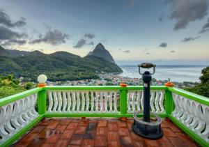 苏弗里耶尔Villa Des Pitons的绿色阳台享有大海和山脉的美景。