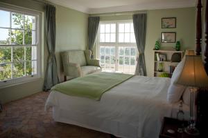 斯泰伦博斯霍克斯莫尔豪斯酒店的一间卧室配有一张床、一把椅子和窗户。