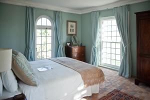 斯泰伦博斯霍克斯莫尔豪斯酒店的一间卧室设有一张大床和两个窗户。