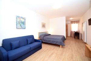 佩斯基奇Residenza Montegrappa的客厅配有蓝色的沙发和床。
