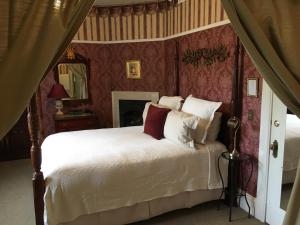 纳帕Churchill Manor的卧室配有白色的床铺和红色的墙壁