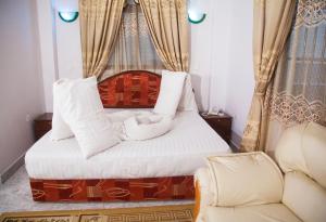 阿鲁沙纳特龙宫宾馆的一间卧室配有一张床和一张沙发