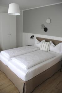 诺德代希Strandhuus Norddeich的一张配有白色床单和枕头的大床