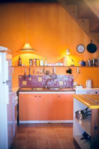 Rosières马斯布罗spa度假旅馆的厨房设有橙色墙壁和水槽