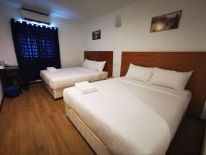 双溪大年Amanjaya Hotel的一间卧室设有两张床、一张桌子和一个窗口。