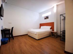 双溪大年Amanjaya Hotel的卧室配有1张床、1张桌子和1把椅子
