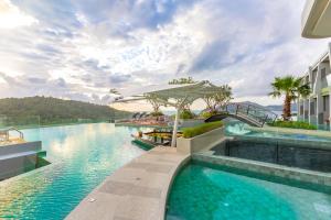 芭东海滩Crest Resort & Pool Villas - SHA Extra Plus的度假村的游泳池,里面装有小船