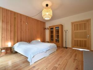 CuzyModern apartment in Cuzy with shared pool的卧室设有白色的床和木墙