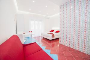 马奥莱德罗莎酒店的客厅配有红色的沙发和床。