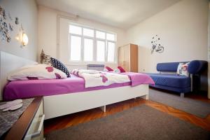 图兹拉Central Tuzla apt - free parking的一间卧室配有一张大床和一张蓝色的沙发