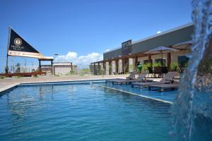 阿拉卡茹Tropical Mar Hotel的一个带椅子的游泳池以及一个喷泉