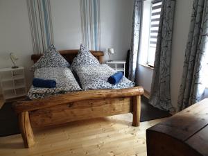 巴特"kleine Boddenburg"的卧室配有带枕头的木床和窗户。