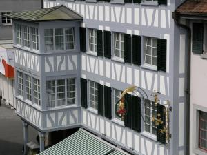巴拉赫兹姆戈尔德恩科弗酒店餐厅的白色的建筑,设有绿色百叶窗和阳台