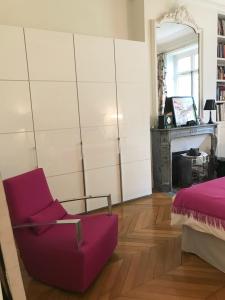 巴黎Parc Monceau的客厅配有紫色椅子和壁炉