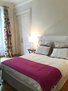 巴黎Parc Monceau的一间卧室配有一张大床和紫色毯子